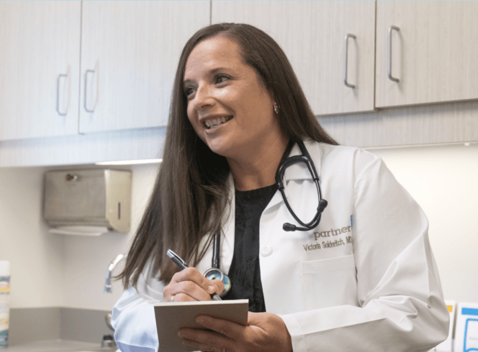Dr. Solderitch taking notes while listening to a patient. 