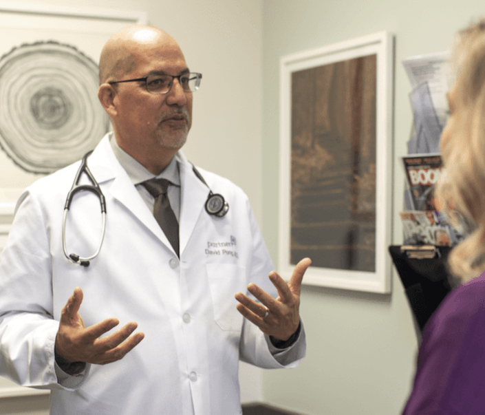 Dr. David Pong, concierge doctor, talking with patient in exam room. 