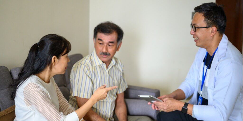 Primary care physician with patients in his office