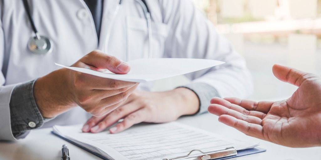 Physician filling out paperwork for insurance. 