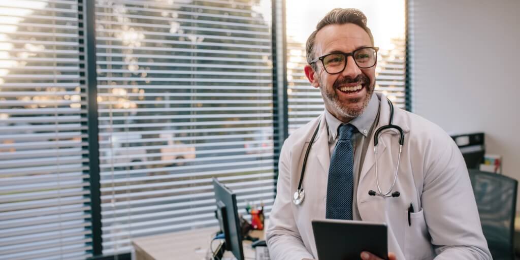 Male concierge doctor laughing in office