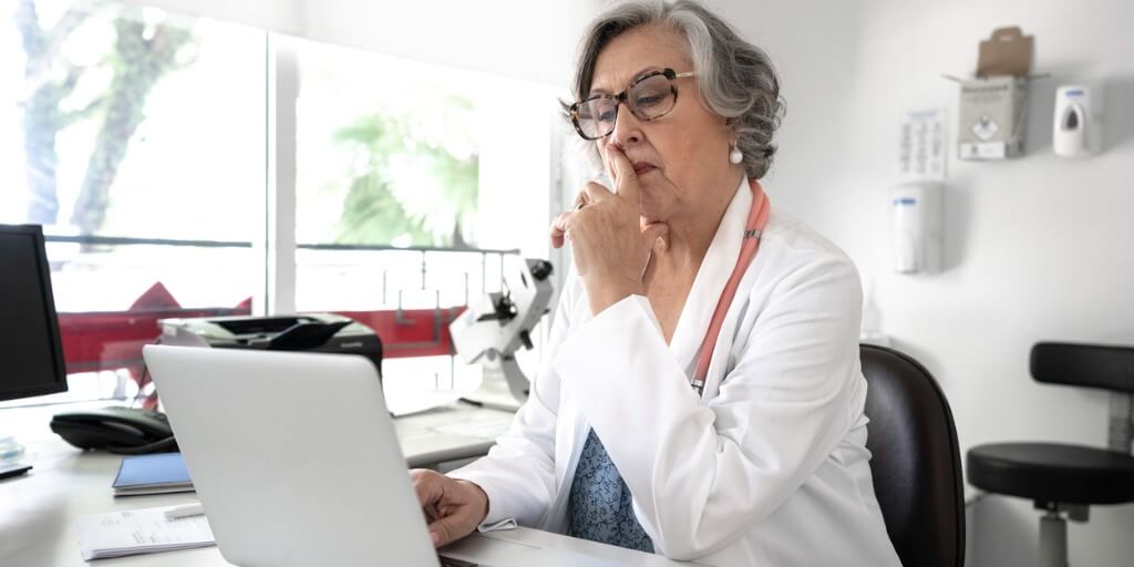 Older female physician at computer