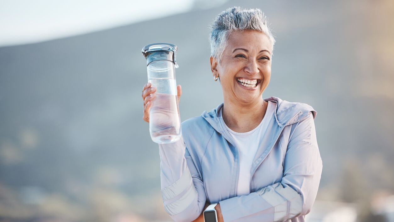 Smiling woman with a water bottle while on vacation