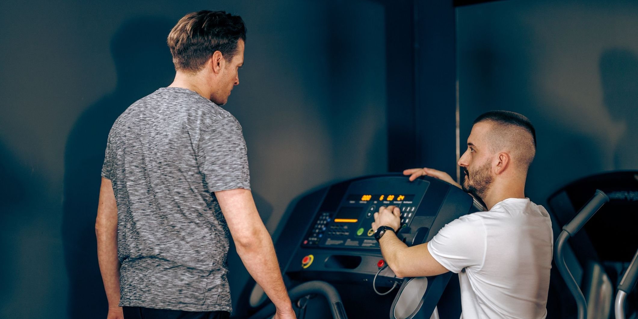 Man with coach at gym.