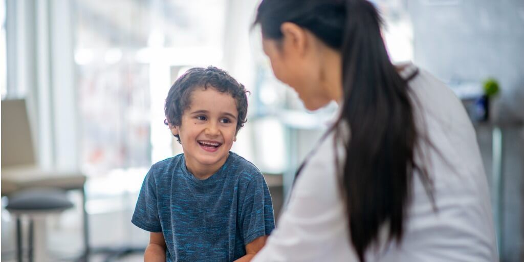 Female concierge doctor making a young boy laugh. 