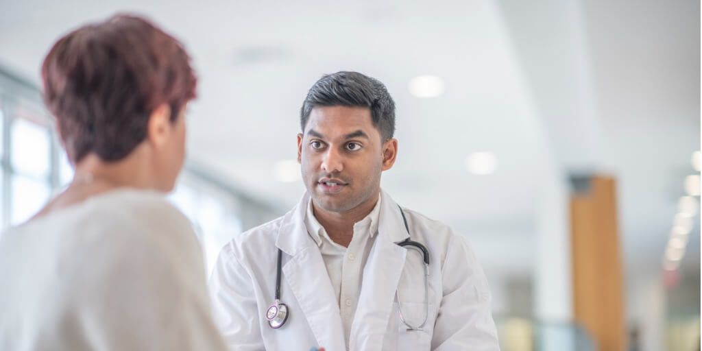 Male physician speaking with female patient