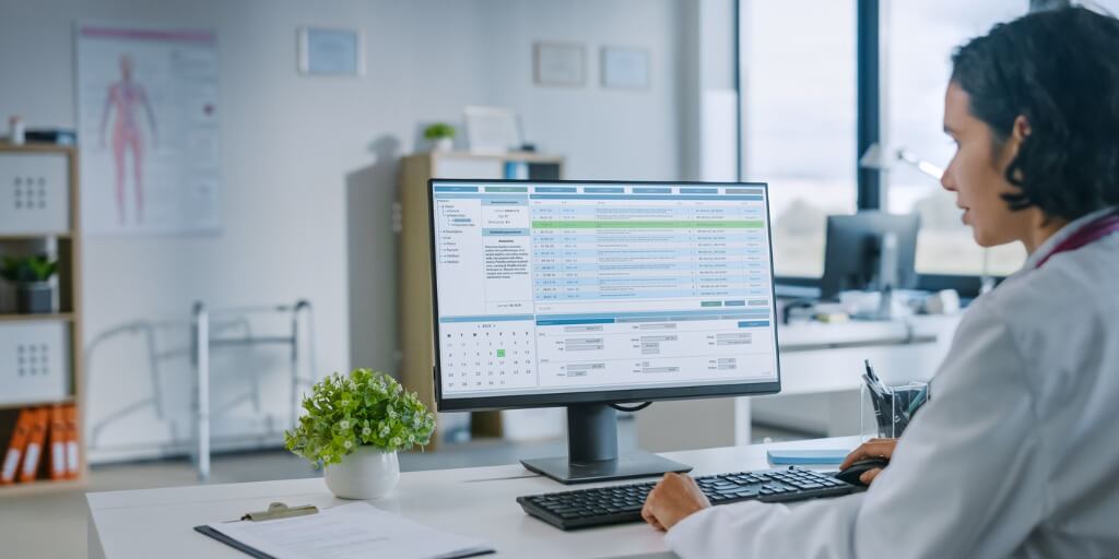 Concierge doctor using a computer to analyze data. 