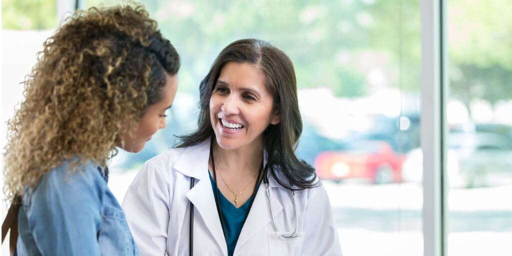 Female concierge physician talking with patient in office