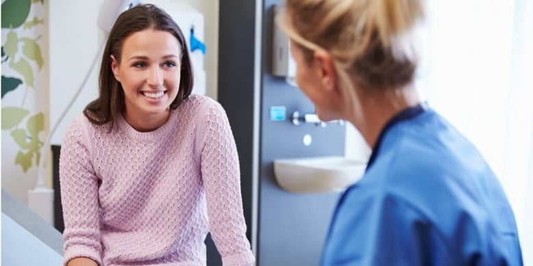 Patient talking with their doctor in an exam room