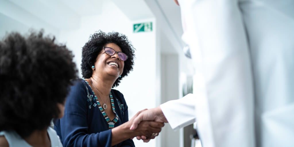 Patient happily shaking hands with physician