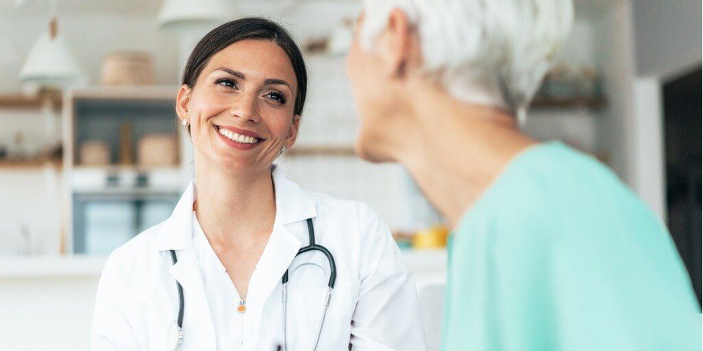 Younger female physician chatting with an older patient