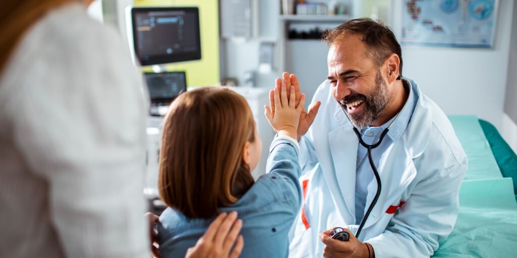 Family medicine physician high fiving young patient