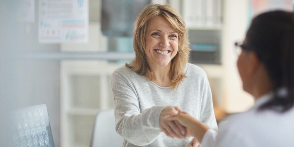 Female patient shaking hands with their doctor. 