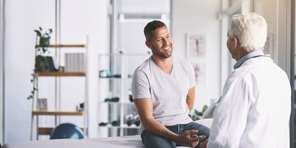 Younger male patient talking with concierge doctor. 