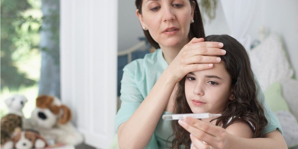 Mother taking temperature of her sick child. 