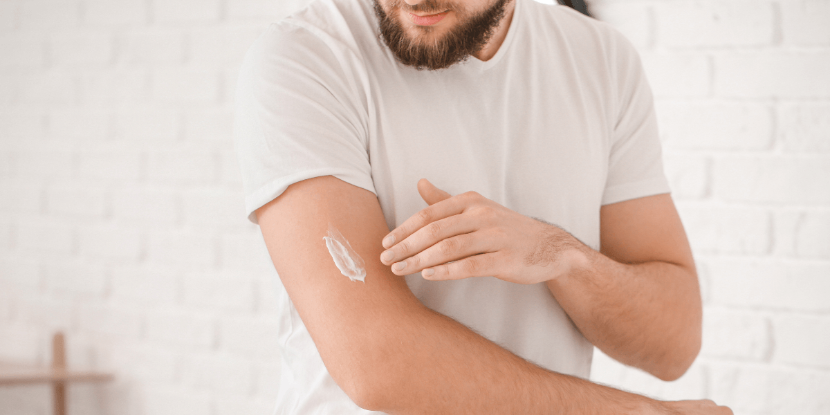 Man applying cream to arm
