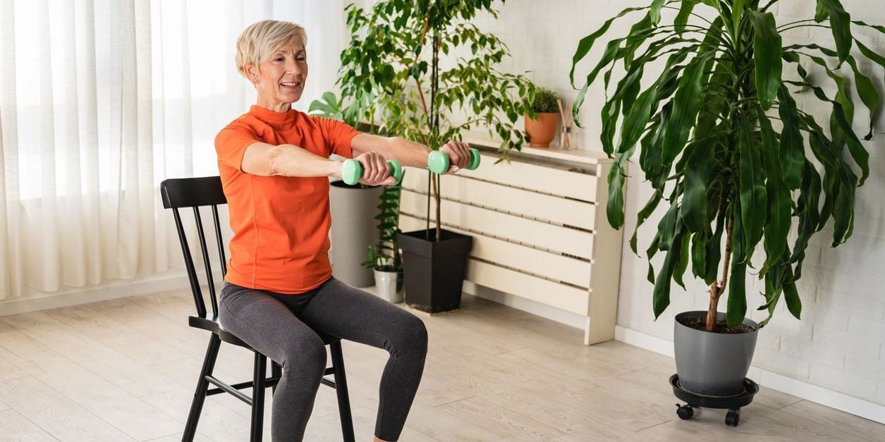 Woman doing upper body chair exercise.