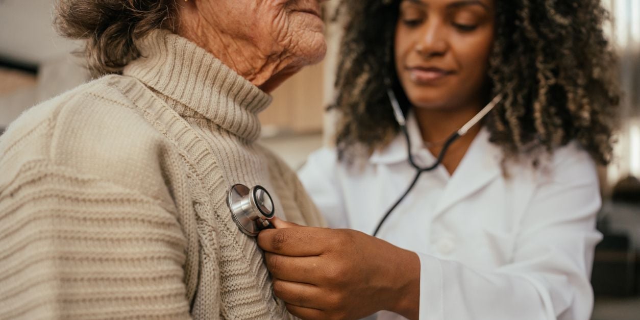 Doctor using stethoscope on patient.