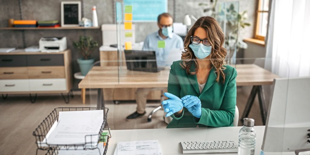 businesswoman-putting-on-protective-gloves-in-the-office-picture-id1241932606