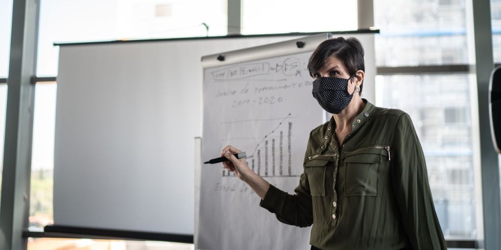 businesswoman-speaking-at-a-business-conference-with-face-mask-picture-id1257195590