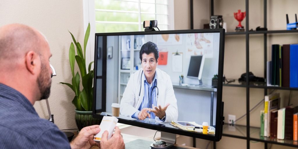 man-uses-desktop-computer-to-video-conference-with-doctor-picture-id1227588588