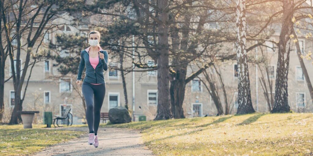 woman-jogging-down-a-path-boosting-her-immune-system-for-covid19-picture-id1214245205