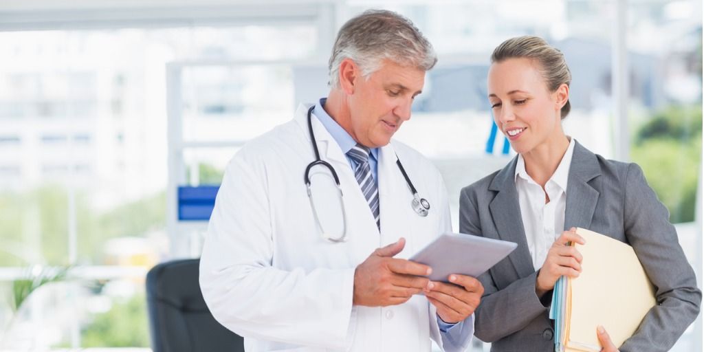 Male physician discussing test results with a female patient after executive physical
