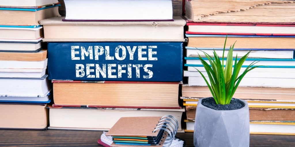 Stack of books on a table, one binding says Employee Benefits