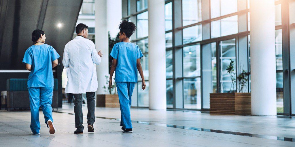 Three doctors walking together in a hospital. 