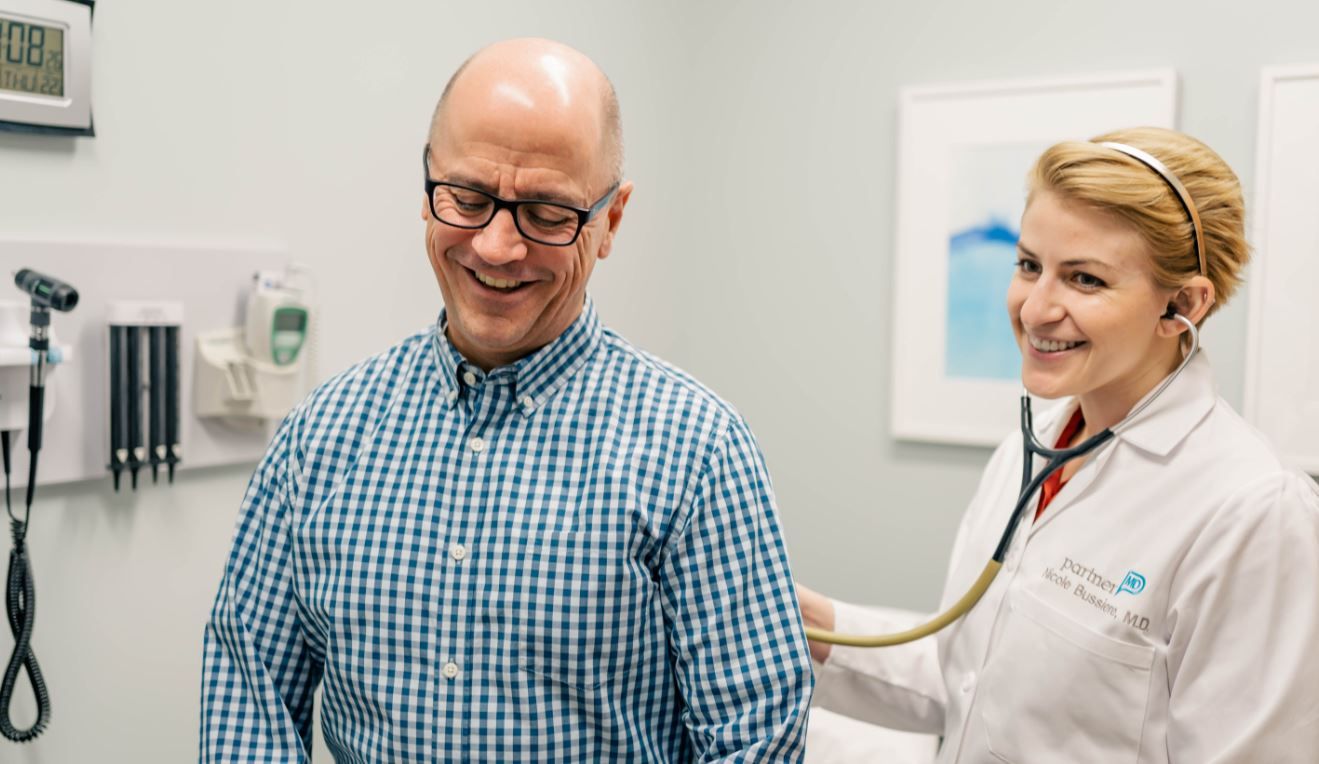 Dr. Bussiere listening to a patient with her stethoscope