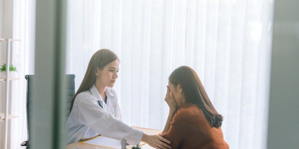 Physician counseling a distressed female patient