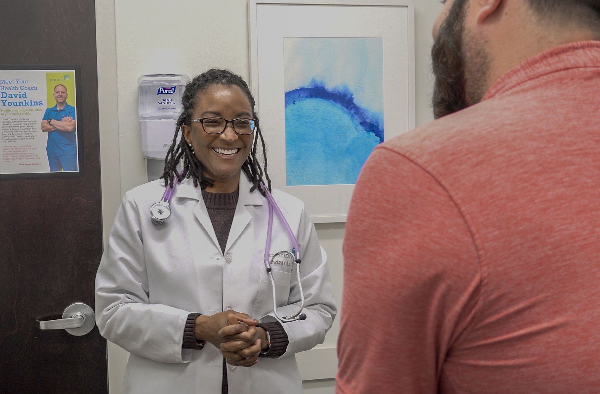 Dr. Lauren Goode, a concierge doctor in Richmond, laughs while talking to a patient in an exam room