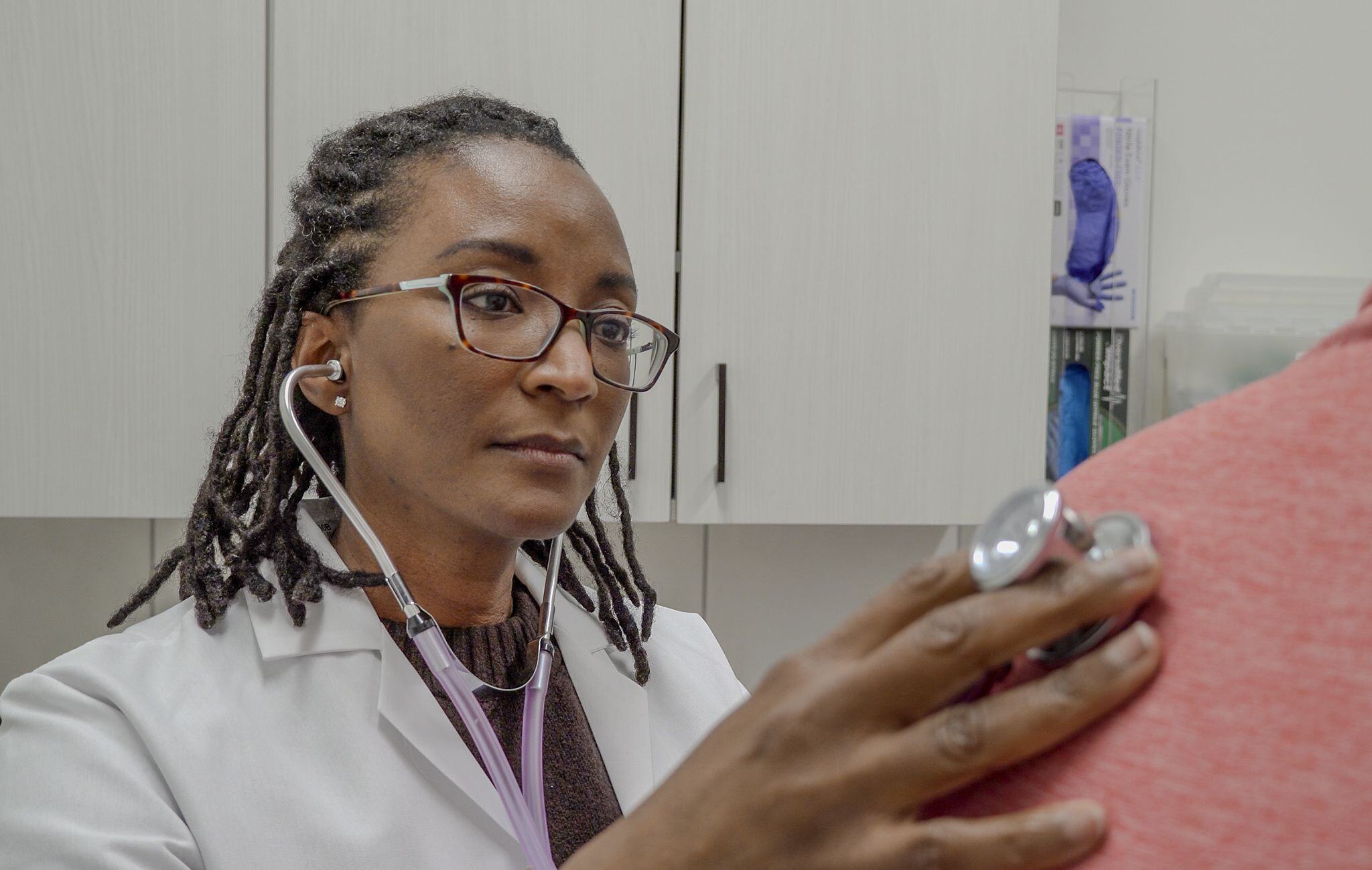 Dr. Lauren Goode, concierge doctor in Richmond, listens to a patient with a stethoscope
