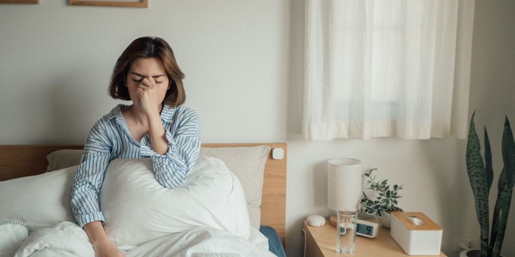 Tired woman at home in bed during the day