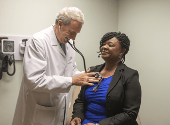Dr. Mumper listening to the chest of a patient with stethoscope