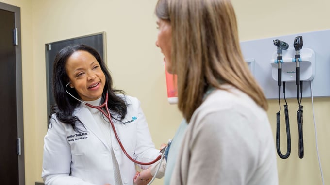 Dr. Jennifer Tutt listening to a patient with stethoscope