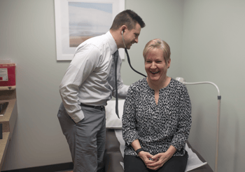 Dr. Bishop listens to a patient with his stethoscope