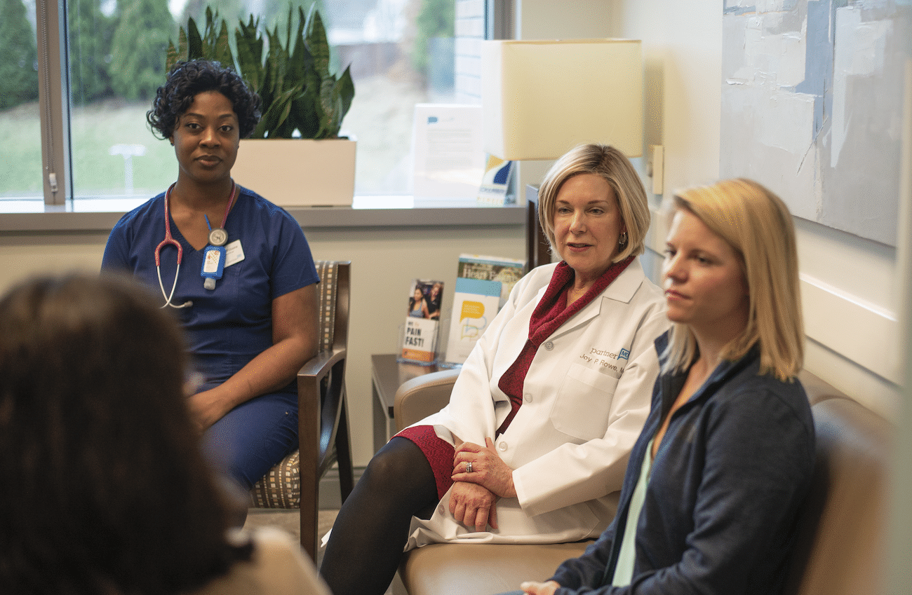Nurse, doctor, and health coach meeting with patient
