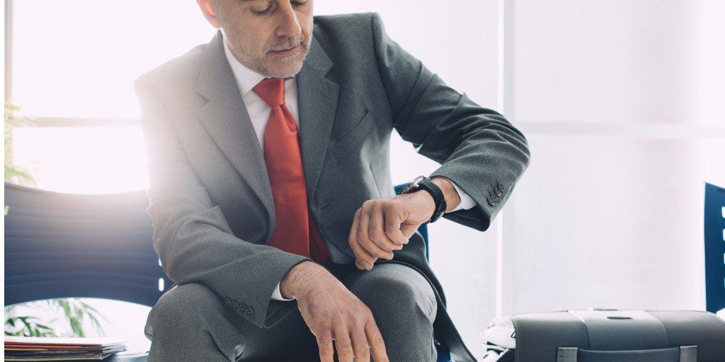 man in a suit checking his watch