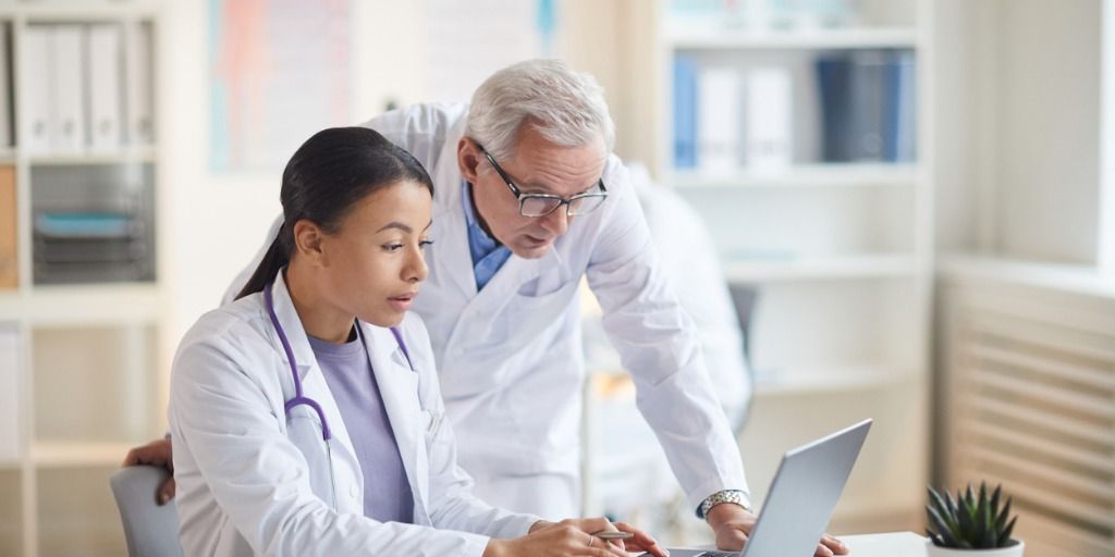 Two physicians working together on a computer