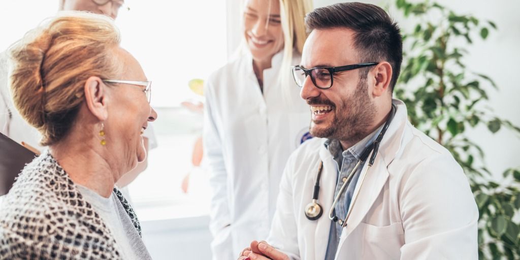 Male physician laughing with female patient