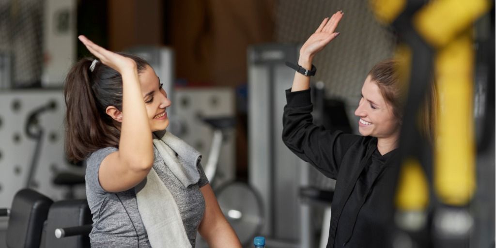 Two women high fiving at a gym