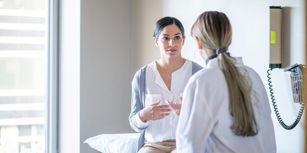 Young mother meeting with her primary care physician in exam room