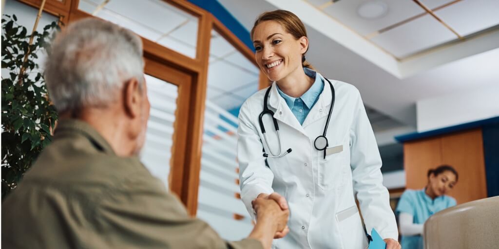 Female physician shaking hand of new patient