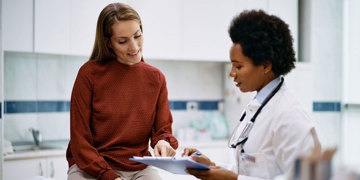 Woman talking to doctor during physical