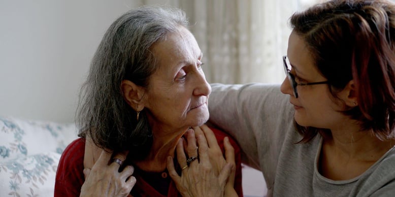 an older woman and middle aged woman looking at each other 