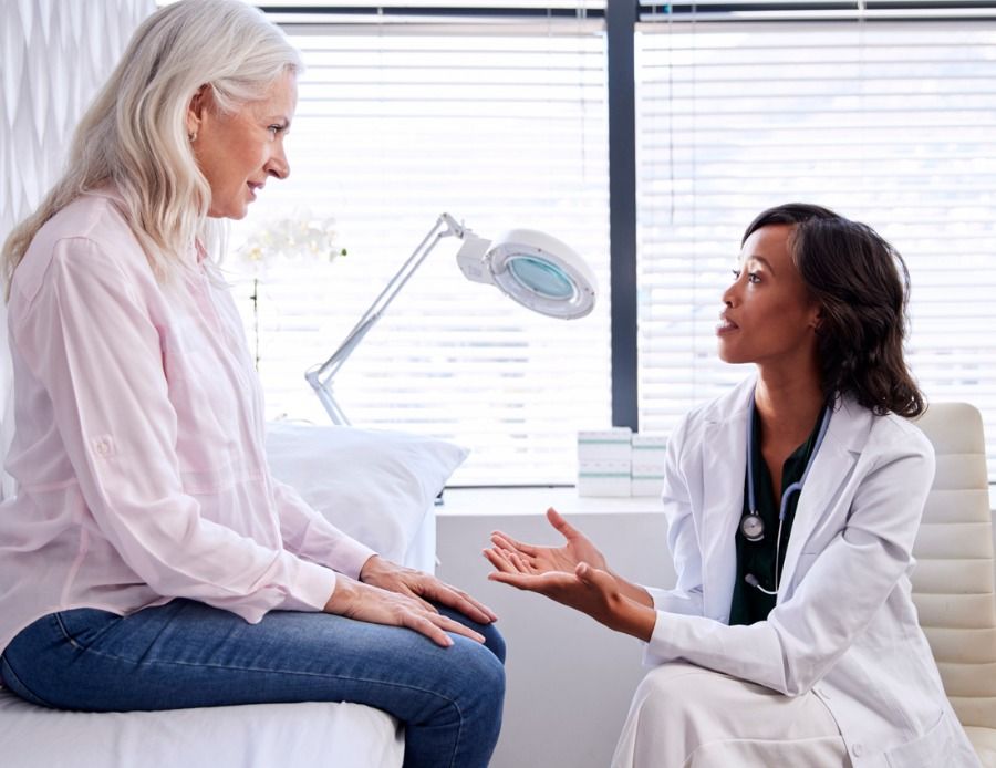 mature-woman-in-consultation-with-female-doctor-sitting-on-couch-in-picture-id1147974101