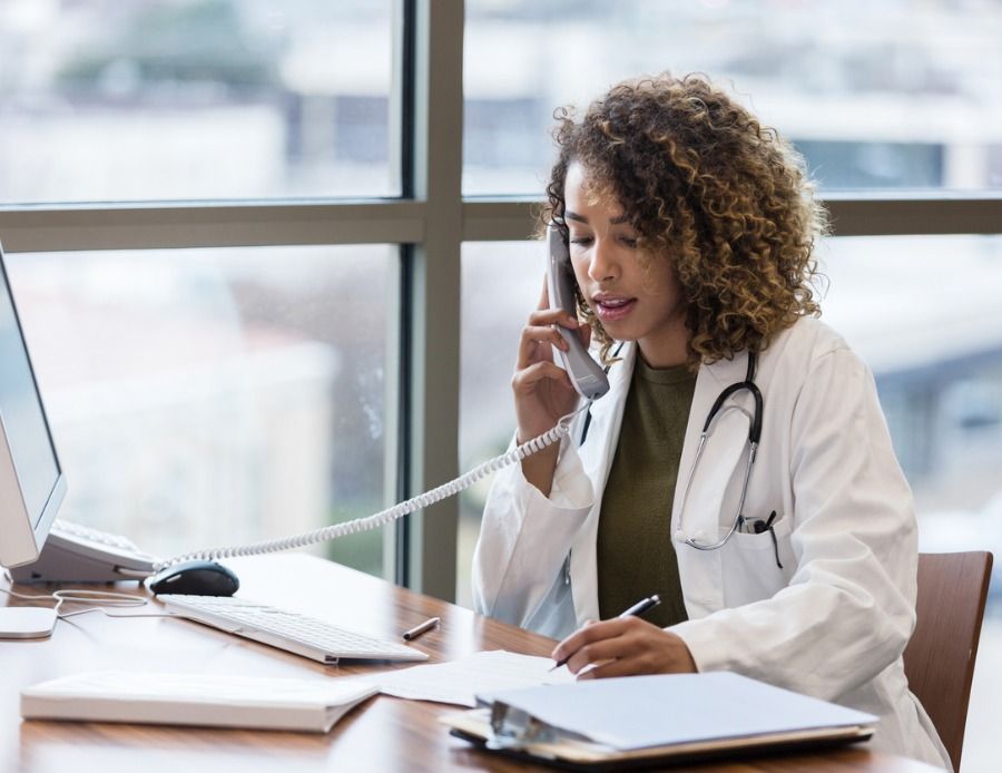 mid-adult-female-doctor-makes-phone-call-regarding-patient-records-picture-id1204472654 (1)-1