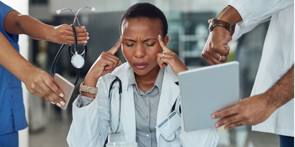 Stressed out doctor with many things being presented to her.