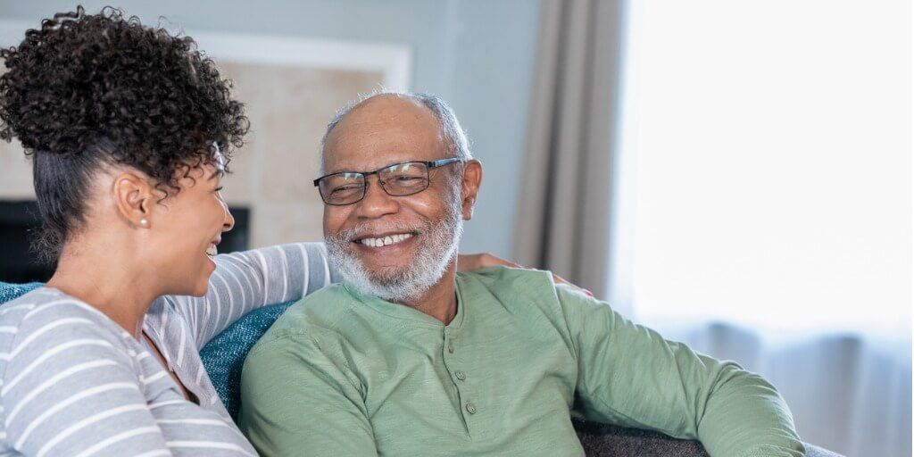 Daughter sitting and laughing with her aging father